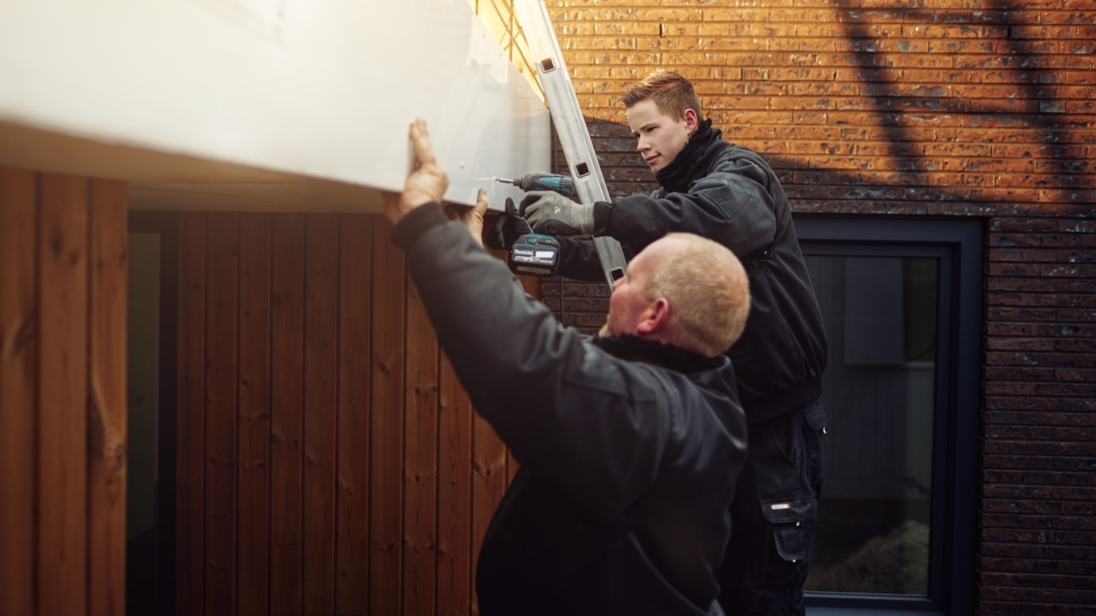 Twee mannen monteren een kunststof boeideel.